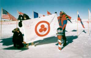 V. Chukov (Russia), V. Drabo (Belarus), and worker of the American Pole Station “Amundsen-Scott” with the Banner of Peace on the South Pole. January 8, 2000.